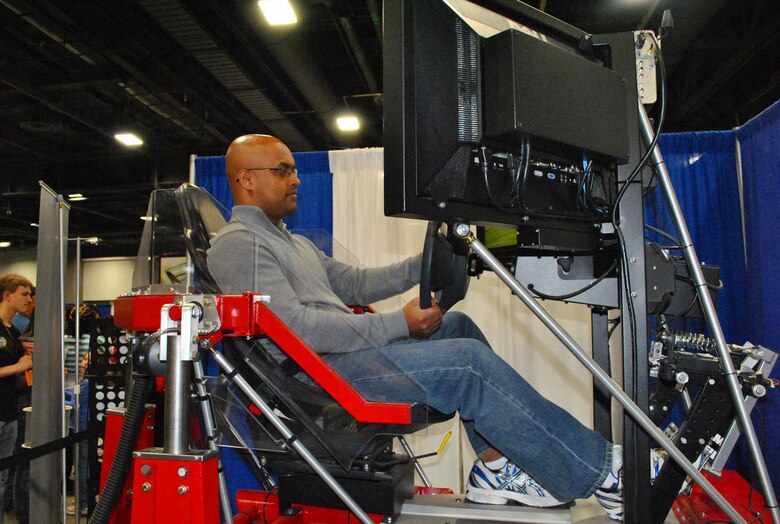 WASHINGTON, D.C. — Gopa Nair, a father of two little girls and computer scientist from Centreville, Va., takes the Synthetic Automotive Virtual Environment or SAVE for a spin at the 2012 USA Science and Engineering Expo here, April 29. SAVE was developed by researchers at the U.S. Army Corps of Engineers' Cold Regions Research and Engineering Laboratory.
