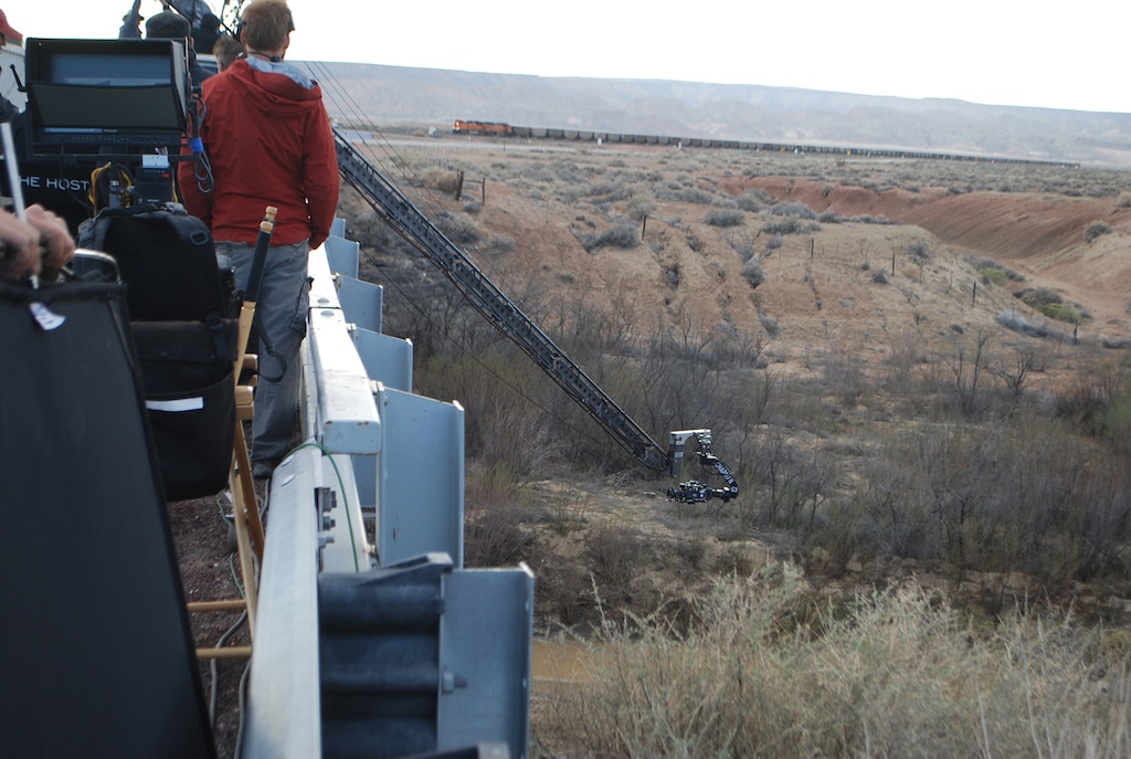 The film crew set up a crane with a camera to take imagery of action taking place under a bridge along the Rio Puerco river. 
