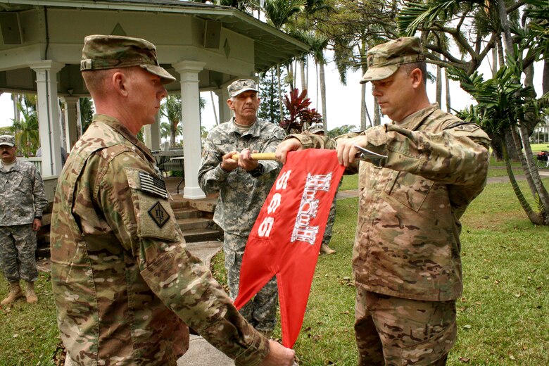 The Honolulu District-based 565th Engineer Detachment, Forward Engineer Support Team-Advance (FEST-A) commander Maj. William Hannan, left,  and Sgt. 1st Class Gary Malkin case the guidon held by cartographer Patrick Bruse during the Deployment Casing Ceremony April 24 at Fort Shafter’s Palm Circle to mark the FEST-A's official deployment to support Operation Enduring Freedom in Afghanistan. 
