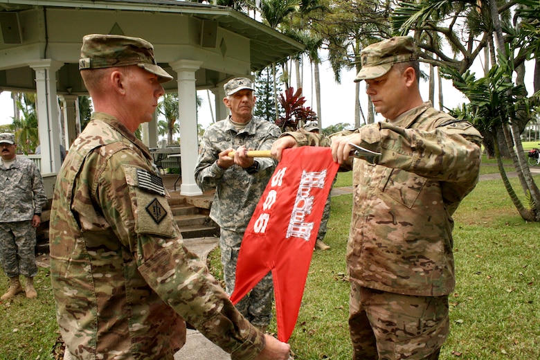 The Honolulu District-based 565th Engineer Detachment, Forward Engineer Support Team-Advance (FEST-A) commander Maj. William Hannan, left,  and Sgt. 1st Class Gary Malkin case the guidon held by cartographer Patrick Bruse during the Deployment Casing Ceremony April 24 at Fort Shafter’s Palm Circle to mark the FEST-A's official deployment to support Operation Enduring Freedom in Afghanistan. 