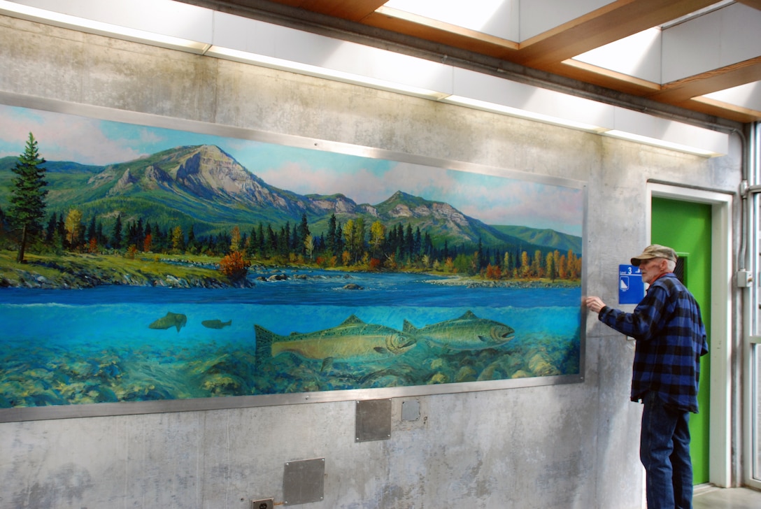 Lee Jensen inspects a mural of swimming fish he had painted years ago. Bonneville Lock and Dam is known for many things, like history and hydropower, but artwork? Lee Jensen, who worked there between 1991 and 2001, left his mark ... in a very creative way.