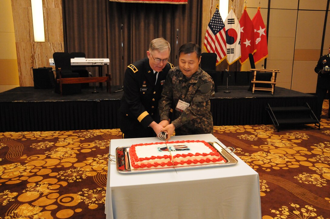 Maj. Gen. Dennis E. Jacobson, Assistant Chief of Staff for Transformation, U.S. Forces Korea, and Brig. Gen. Park Jong-gwan, Jacobson’s counterpart in the Republic of Korea Army, cut the cake at the Society of American Military Engineers Peninsula Engineer Conference Ice Breaker April 4.  
