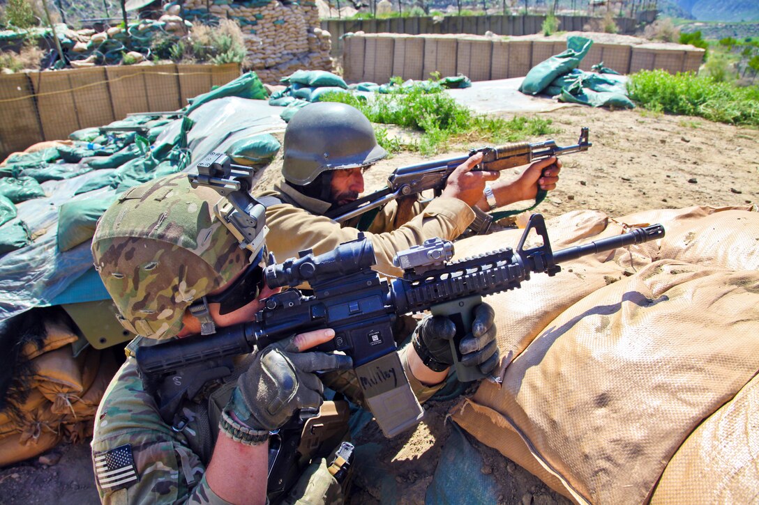 U.S. Army Spc. Jeremy Mulloy, left, and an Afghan guard provide security on Contingency Operating Post Pirtle King in Afghanistan's Kunar province, April 18, 2012. Mulloy is assigned to the 15th Psychological Operations Battalion, 2nd Psychological Operations Group, Tactical Psychological Operations Team 1556.