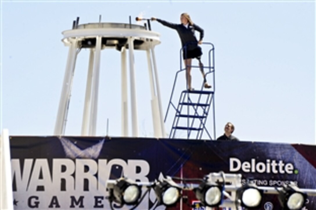 Retired Army veteran Melissa Stockwell performs the torch-lighting ceremony with Royal Marine Capt. Simon Maxwell to kick off the 2012 Warrior Games in Colorado Springs, Colo., April 30, 2012. The U.S. Olympic Committee hosts the sporting competition for wounded members of the armed services.