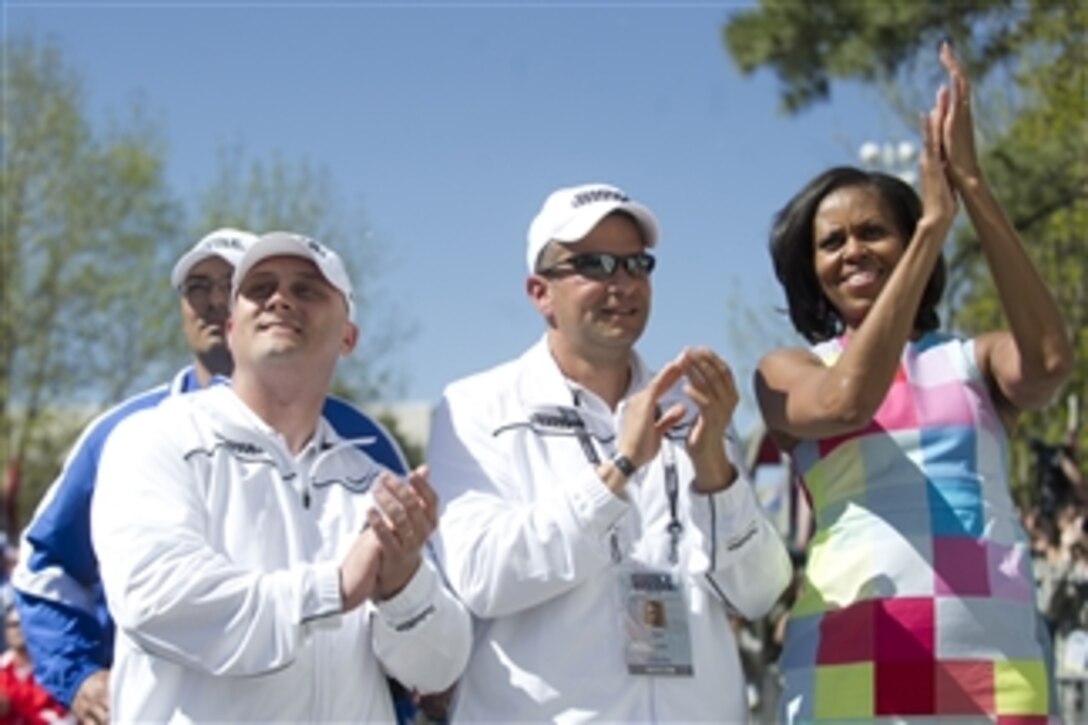 First Lady Michelle Obama joins athletes in applause at the 2012 Warrior Games in Colorado Springs, Colo., on April 30, 2012.  The Warrior Games is an annual event allowing wounded, ill and injured Service members and veterans to compete in Paralympics sports including archery, cycling, shooting, sitting volleyball, track and field, swimming and wheelchair basketball.  