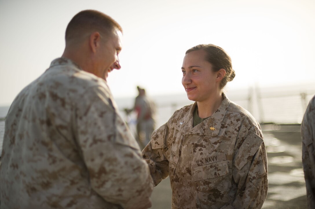 Navy Lt. j.g. Chelsea McLean shakes hands with Maj. Bradley Ward before being awarded the Navy and Marine Corps Achievement Medal during a ceremony aboard USS Pearl Harbor May 1. McLean hails from Charlottesville, Va., and serves as a physician assistant with Combat Logistics Battalion 11, which provides logistics and services for the 11th Marine Expeditionary Unit. The unit is deployed as part of the Makin Island Amphibious Ready Group, currently a U.S. Central Command theater reserve force. The group is providing support for maritime security operations and theater security cooperation efforts in the U.S. Navy's 5th Fleet area of responsibility.