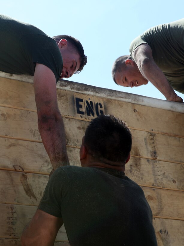 Marines from 10th Marine Regiment, 2nd Marine Division, climb a wall during  the Engineer’s Challenge Obstacle Course.  The event was part of the first 10th Marines’ Kings’ Games, a regiment-wide competition to build camradarie throughout 10th Marines.  The course was constructed by engineers from the regiment  days before the competition to challege competitors physically and mentally. (Official U.S. Marine Corps photo by Cpl. Tommy Bellegarde)