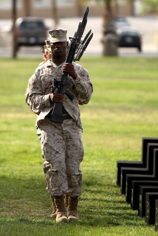 Lance Cpl. Jamal Boykins, mortorman, 3/7, leads a small detail of Marines with M16A2 service rifles in placing the first elements of the battlefield crosses. (Official USMC photo by Diane Durden)