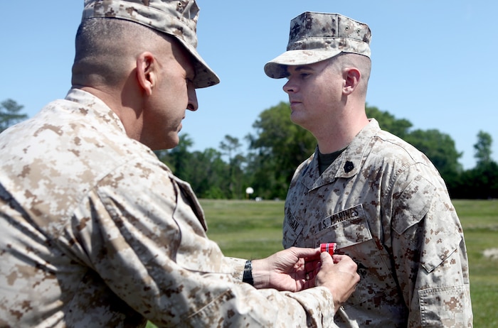 Gunnery Sgt. Robert L. Jernigan, of Gates County, N.C., receives the Bronze Star Medal with Combat Distinguishing Device from Maj. Gen. Michael G. Dana, the 2nd Marine Logistics Group commanding general, during a ceremony aboard Camp Lejeune, N.C., May 2. While serving as a joint terminal attack controller attached to 2nd MLG (Forward) in Afghanistan last year, Jernigan’s expert control of air assets was directly responsible for quelling an ambush and undoubtedly saved countless lives. (U.S. Marine Corps photo by Cpl. Jessica Gonzalez)