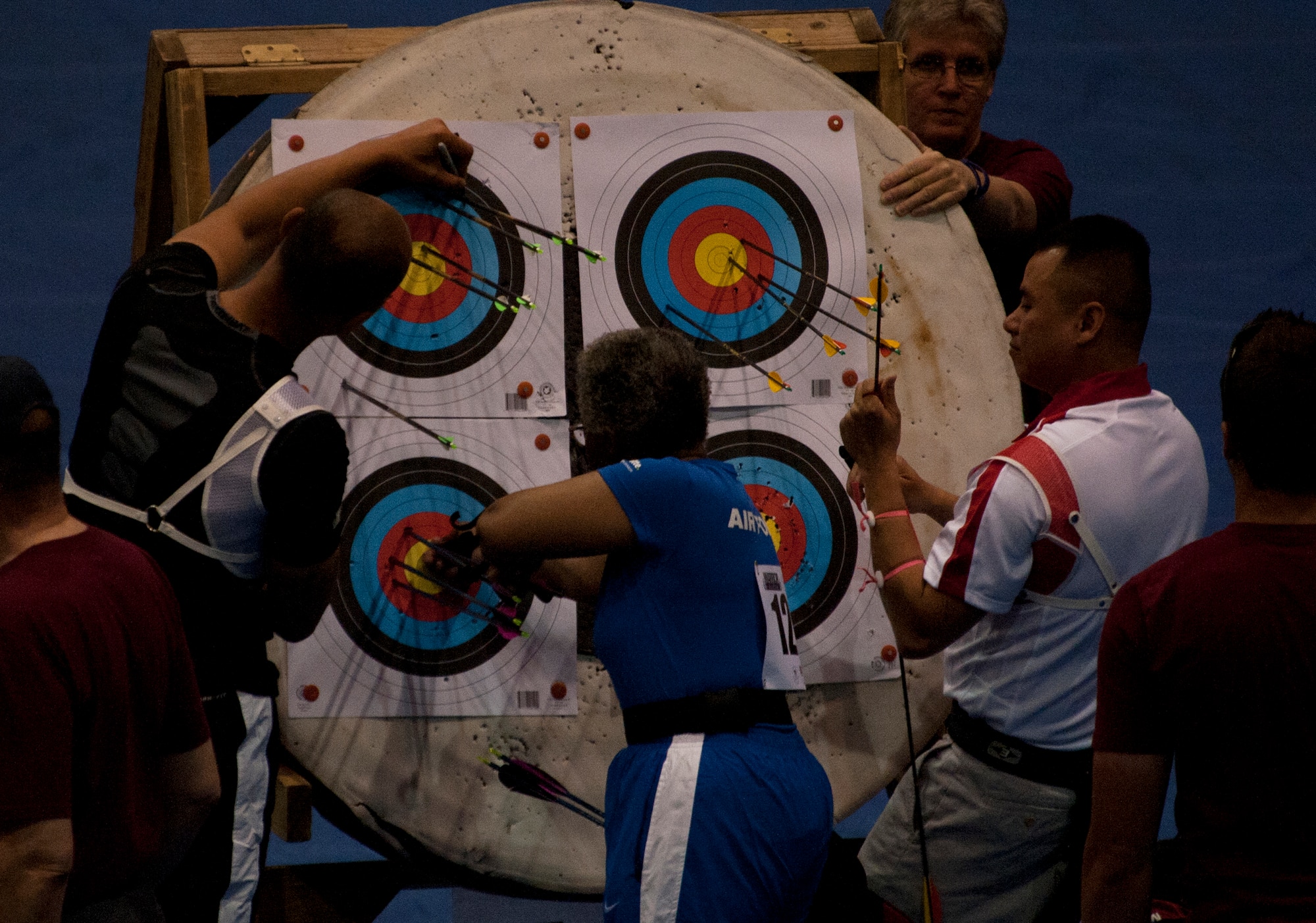 Gwen Sheppard (center) removes the arrows from her target during the archery competition of the 2012 Warrior Games at the U.S. Air Force Academy in Colorado Springs, Colo., May 2, 2012. Sheppard is with the Air Force team. (U.S. Air Force photo/Val Gempis) 