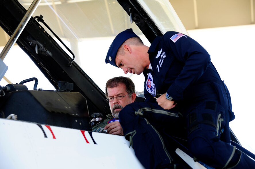 U.S. Air Force Lt. Col. Jason Koltes, operations officer for the U.S. Air Demonstration Squadron Thunderbirds, gives an explanation of the inside of Thunderbird 7 to Derek Burress, host for the “Good Morning Sumter” broadcast, at Shaw Air Force Base, S.C., May 2, 2012. The Thunderbirds are at Shaw for the Shaw Air Expo May 5 and 6. The Shaw Air Expo will have aircraft performances, displays and other entertainment vendors for all ages. (U.S. Air Force photo by Airman 1st Class Hunter Brady/Released) 
