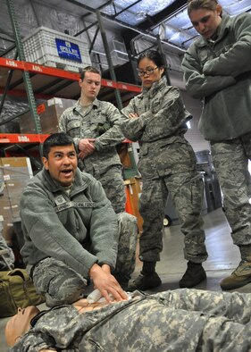 Master Sgt. Edrid Tirado, 446th Aeromedical Staging Squadron, demonstrates proper treatment of an open wound during the self-aid and buddy care portion of “Ability to Survive and Operate” training May 1, 2012, at Joint Base Lewis-McChord, Wash. (U.S. Air Force photo/Senior Airman Leah Young)