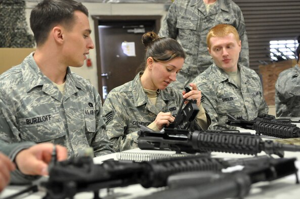 Staff Sgt. Allison Cismowski, center, 627th Logistics Readiness Squadron, reassembles an M-16 during the weapons familiarization portion of “Ability to Survive and Operate” training May 1, 2012, at Joint Base Lewis-McChord, Wash. While rotating between stations, Airmen discussed several ATSO topics including self-aid and buddy care, weapons familiarization and force protection conditions. (U.S. Air Force photo/Senior Airman Leah Young)
