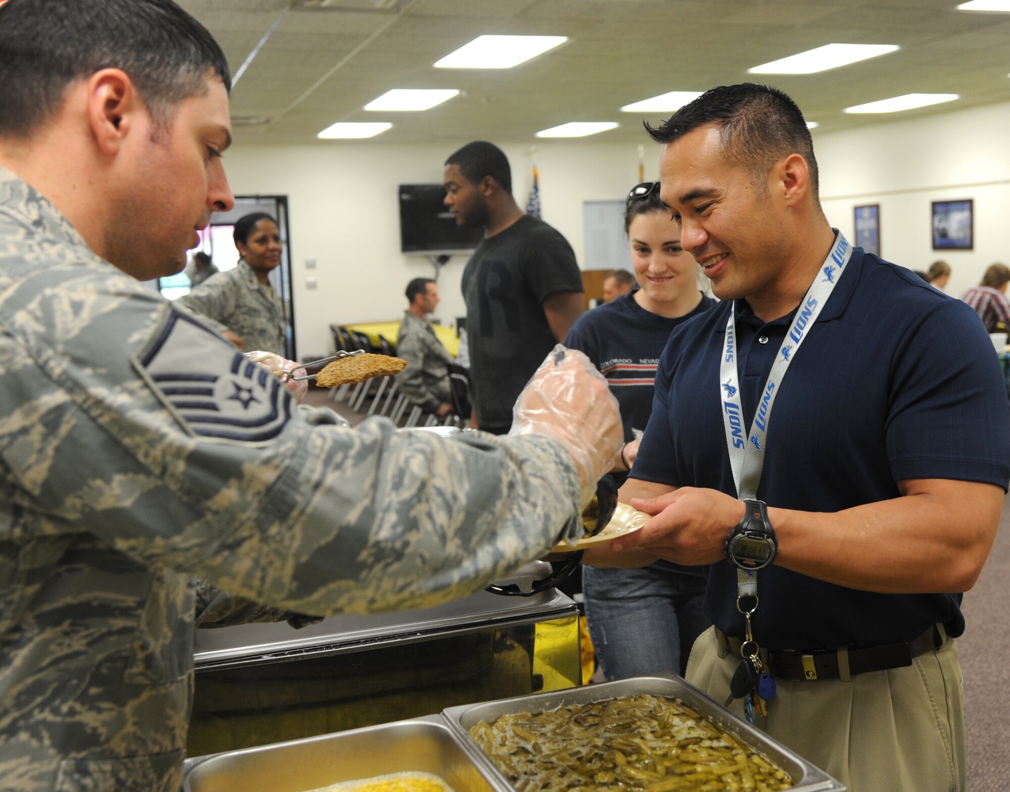 Master Sgt. David Lenamond, left, the superintendent of the 71st Logistics Readiness Squadron, serves Tech. Sgt. Joseph Gonzales, with the 71st Security Forces Squadron, a helping of corn and green beans during the Singles’ International Gourmet Meal Opportunity, April 30, at Vance Air Force Base, Okla. (U.S. Air Force photo/ Airman 1st Class Frank Casciotta)