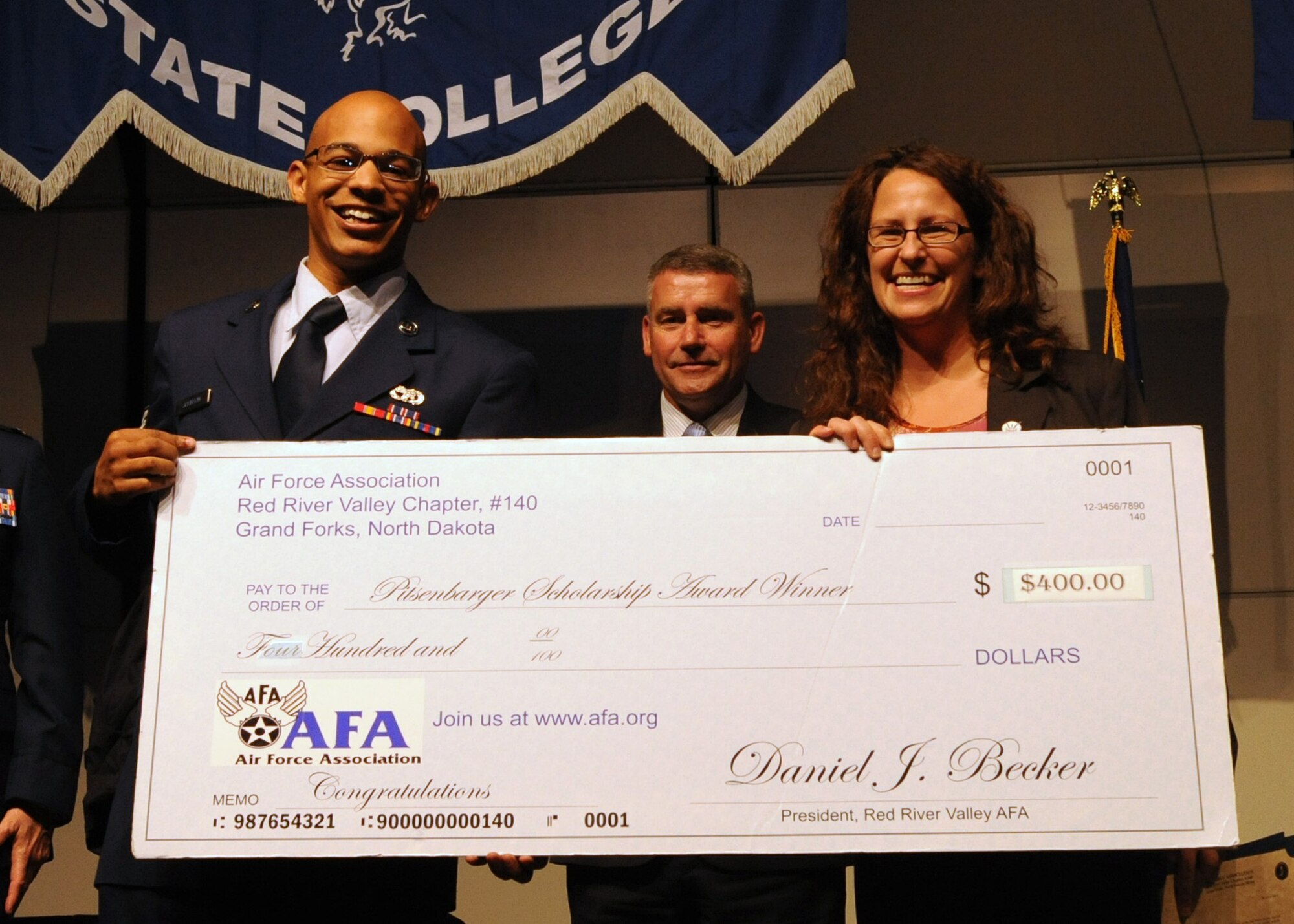 Airman 1st Class Karlon Johnson, of the 319th Logistics Readiness Squadron at Grand Forks Air Force Base, N.D., accepts the Air Force Association Pitsenbarger Award grant of $400 on April 28, 2012, during a ceremony in East Grand Forks, Minn. Johnson was also awarded his Community College of the Air Force degree with 21 other base Airmen during the ceremony. The Pitsenbarger award is given to Airmen who show positive leadership in the community and who selflessly volunteer in extracurricular activities to help others. (U.S. Air Force photo by Senior Airman Amber Bennett)