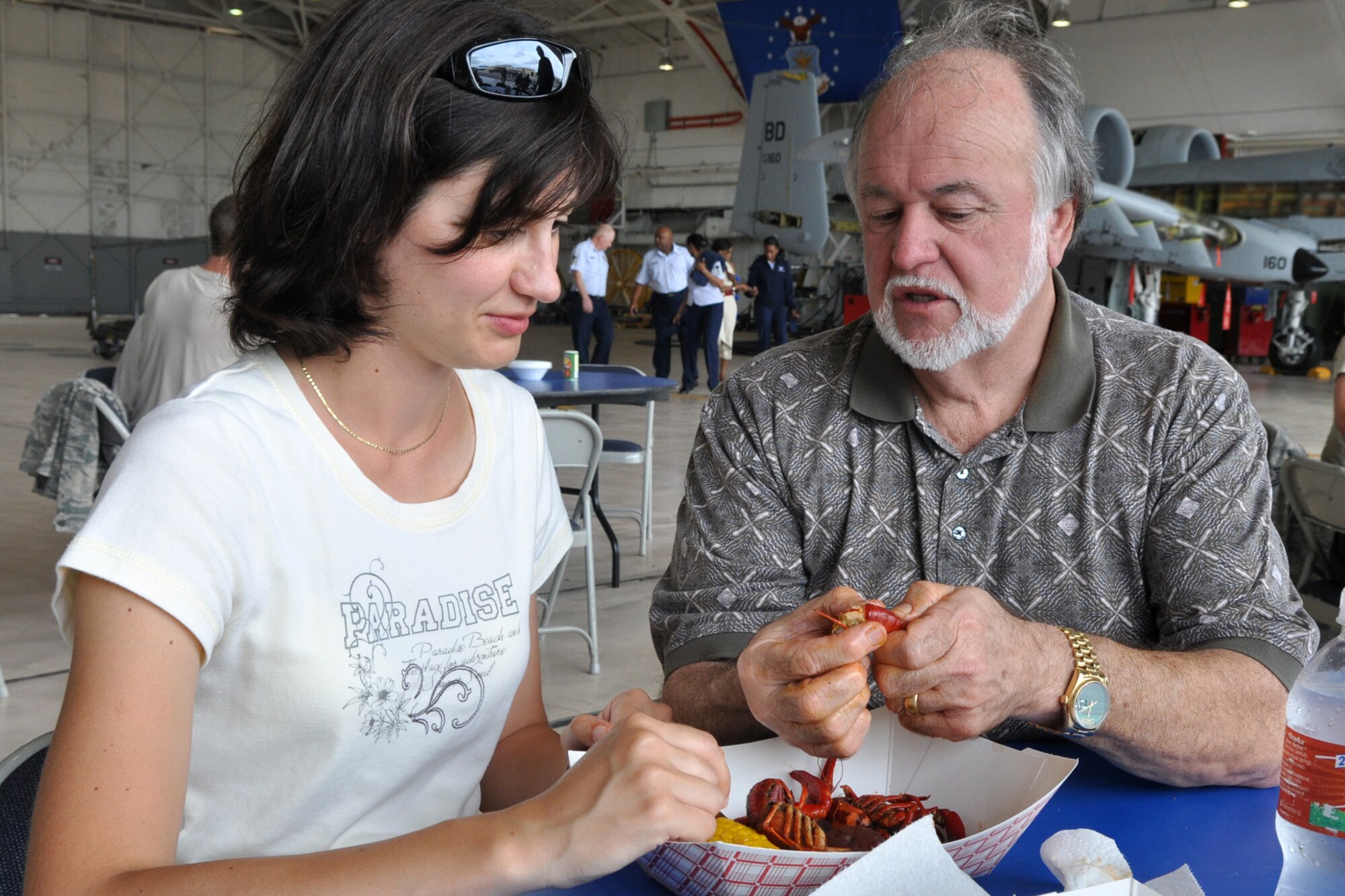Lionel Robin, hospitality chef for Tabasco, demonstrates the delicate procedures for peeling and eating Louisiana crawfish to Eva Klimentova, a visitor to the 307th Bomb Wing, during a crawfish luncheon at the A-10 hangar on Barksdale Air Force Base, La., April 30, 2012. The luncheon, which was held for Airmen from the 307 BW and 917th Fighter Group, was sponsored by Mr. Boyd Parker and Shreveport Rubber and Gasket Company in “appreciation for what Barksdale Air Force Base does for the freedom we enjoy.” (U.S. Air Force photo by Master Sgt. Jeff Walston) 