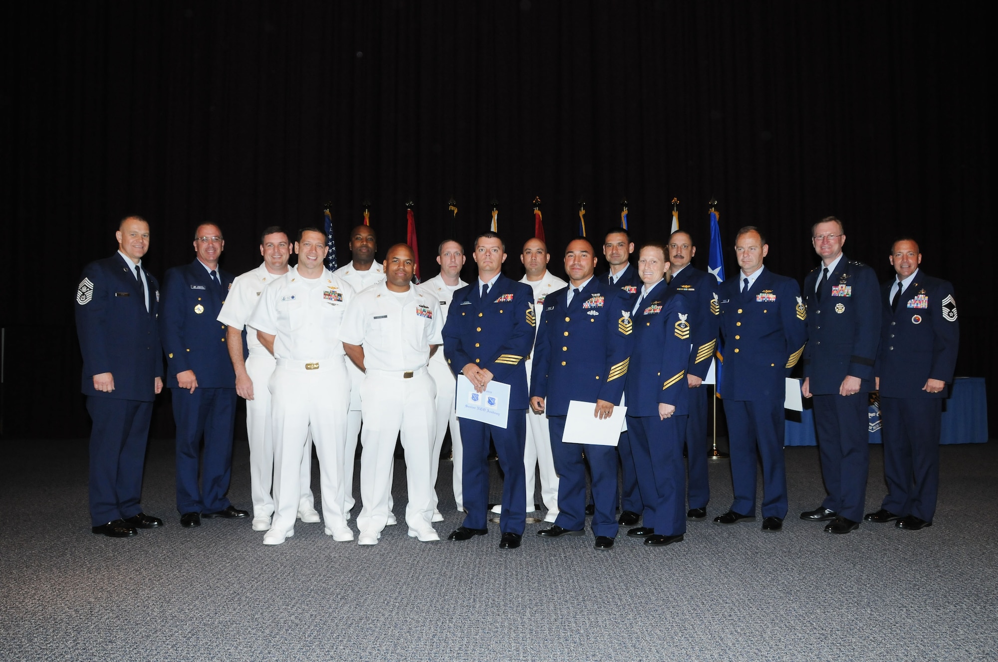 From left, Chief Master Sergeant of the Air Force James Roy is joined by his counterpart, Master Chief Petty Officer of the Coast Guard Michael Leavitt with graduates of the Air Force Senior NCO Academy Tuesday. Featured second from right is Lt. Gen. David Fadok, commander and president of the Air University. Air Force photo by Bud Hancock