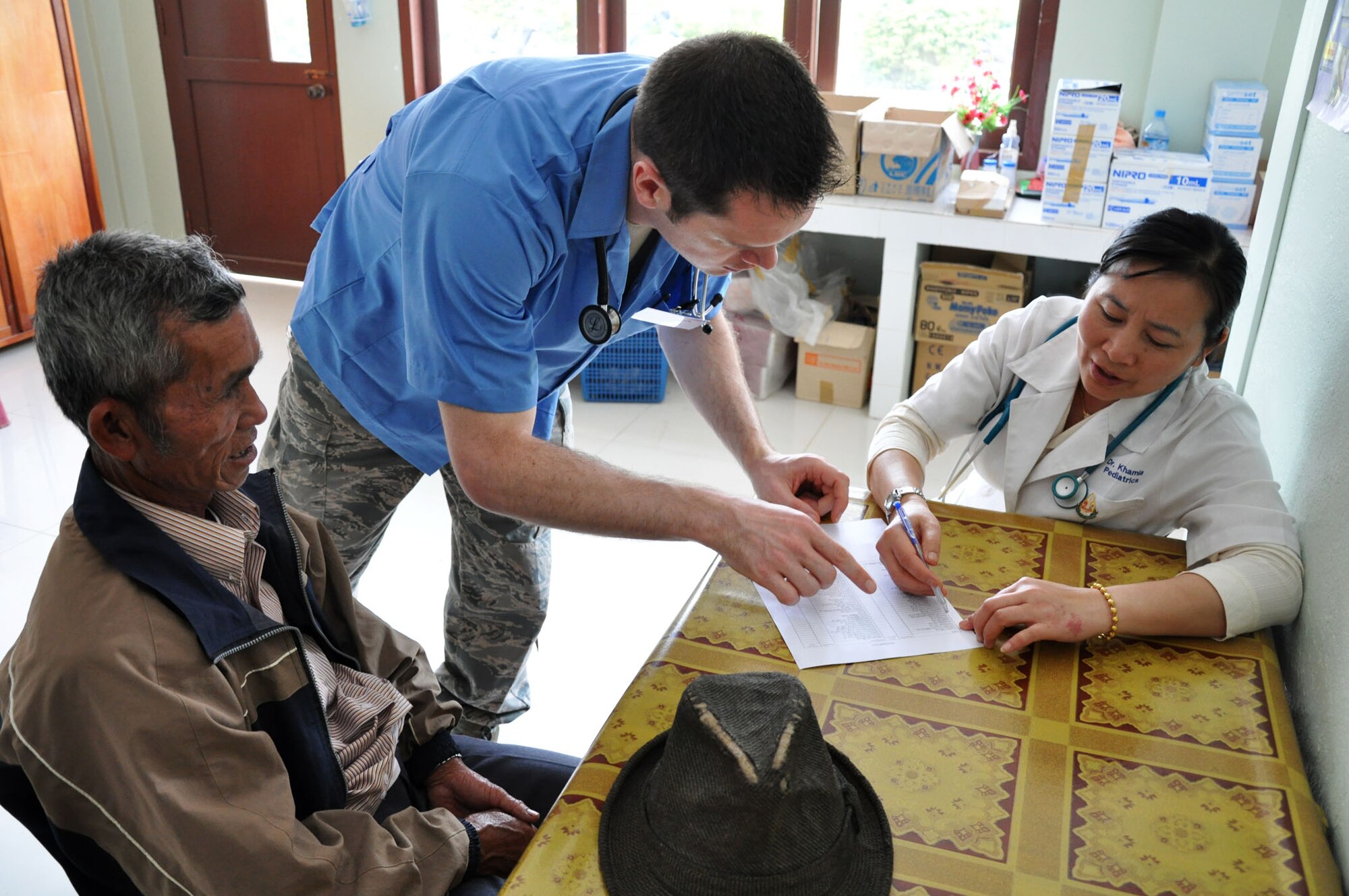 Dr. (Maj.) Cole Taylor and Dr. Khamla consult over the diagnosis of Mr. Pheng Sy, at the Lao-Mongolian Friendship Hospital in Phonsavahn, Laos, April 24. Sy was one of hundreds of patients seeking care on the first day of health service outreach during Operation PACIFIC ANGEL 12-2. In addition to medical treatment, PACANGEL also features medical and engineering subject matter expert exchanges, as well as multiple civil engineer renovation projects. (U.S. Air Force photo/Master Sgt. Mike Hammond)