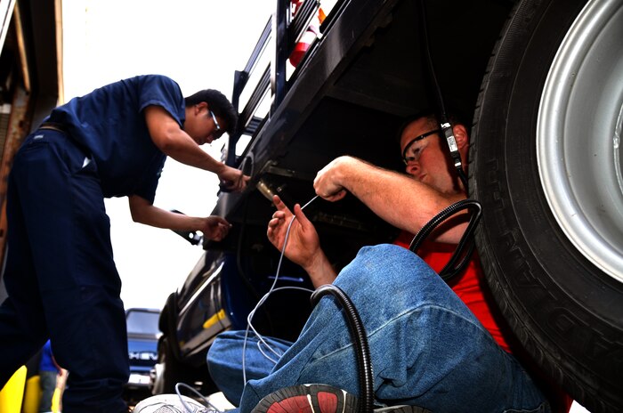 Elmo Lameg (left) and Chris Kemp (right) install the Automotive Information Module, second generation, April 27 at Joint Base Charleston – Air Base. JB Charleston is a testing location for the AIM2 technology. Testing is scheduled to begin in August 2012 and if successful, the program is scheduled to go Air Force-wide in October 2012. Lameg is a vehicle mechanic with the 628th Logistics Readiness Squadron and Kemp is a Syn-Tech Corporation field service technician. (U.S. Air Force Photo / Airman 1st Class Tom Brading)