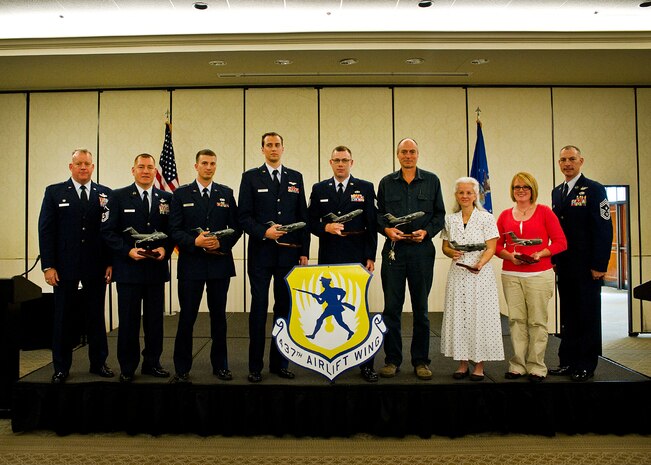 (Left to Right) Col. Erik Hansen, Master Sgt. Rene Delarosa, 1st Lt. Edward Yerage, Capt. Benjamin Wood, Tech. Sgt. Matthew Ancell, Randall Gillum, Tamra Fuchs and Kayle Ealey pose at the conclusion of the 437th Airlift Wing Quarterly Awards ceremony at Joint Base Charleston - Air Base April 27. Hansen is the 437th AW commander, Delarosa is a 15th Airlift Squadron loadmaster superintendent, Yerage is a 437th Aerial Port Squadron ramp operations flight commander, Wood is a 17th Airlilft Squadron chief of tactics and instructor aircraft commander, Ancell is a 437th Maintenance Group quality assurance inspector, Gillum is a 437th Maintenance Squadron machinist and Fuchs is a 437th MXS command section administrator. Kayle Ealey accepted the award for her husband Airman 1st Class Robert Ealey, 437th APS special handling apprentice, and Williams is the 437th AW command chief. (U.S. Air Force photo/Airman 1st Class George Goslin)  
