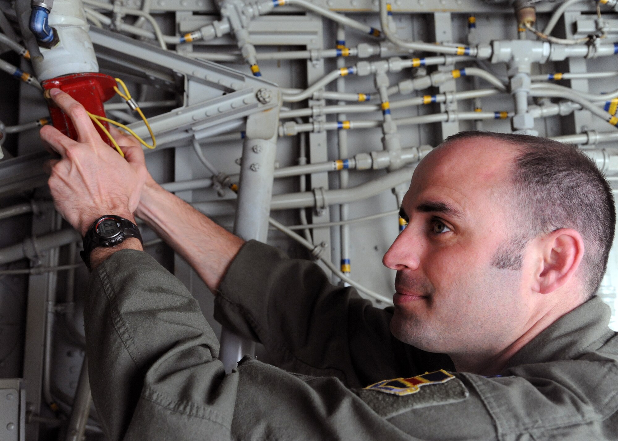 Capt. Nick Phillips, a pilot from Offutt Air Force, Neb., performs maintenance to his aircraft upon arrival at Grand Forks Air Force Base, N.D., on May 1, 2012. Phillips and about 100 other Offutt personnel were diverted to Grand Forks to avoid dangerous weather conditions at their home base. (U.S. Air Force photo by Senior Airman Amber Bennett)