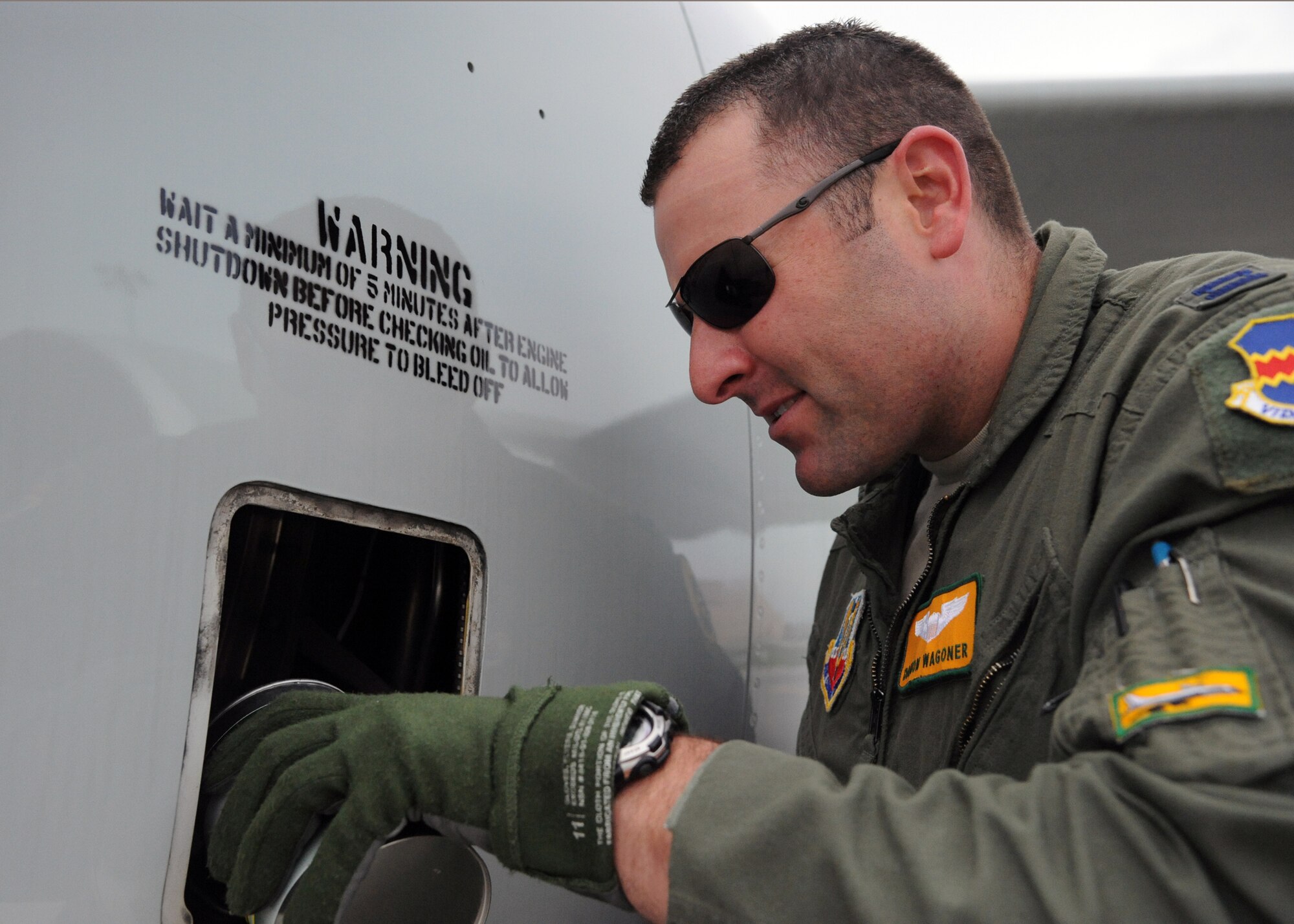 Capt. Damon Wagoner, a pilot from Offutt Air Force, Neb., performs maintenance on his aircraft upon arrival at Grand Forks Air Force Base, N.D., May 1, 2012. Wagoner and about 100 other Offutt personnel were diverted to Grand Forks to avoid dangerous weather conditions at their home base. (U.S. Air Force photo by Senior Airman Amber Bennett)