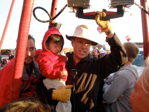 Maj. Kenneth Weiner, 18th Air Force, prepare for take-off while holding his son, Evan. Weiner has been flying balloons since age 14, before he entered the Air Force as a pilot. (Courtesy photo)