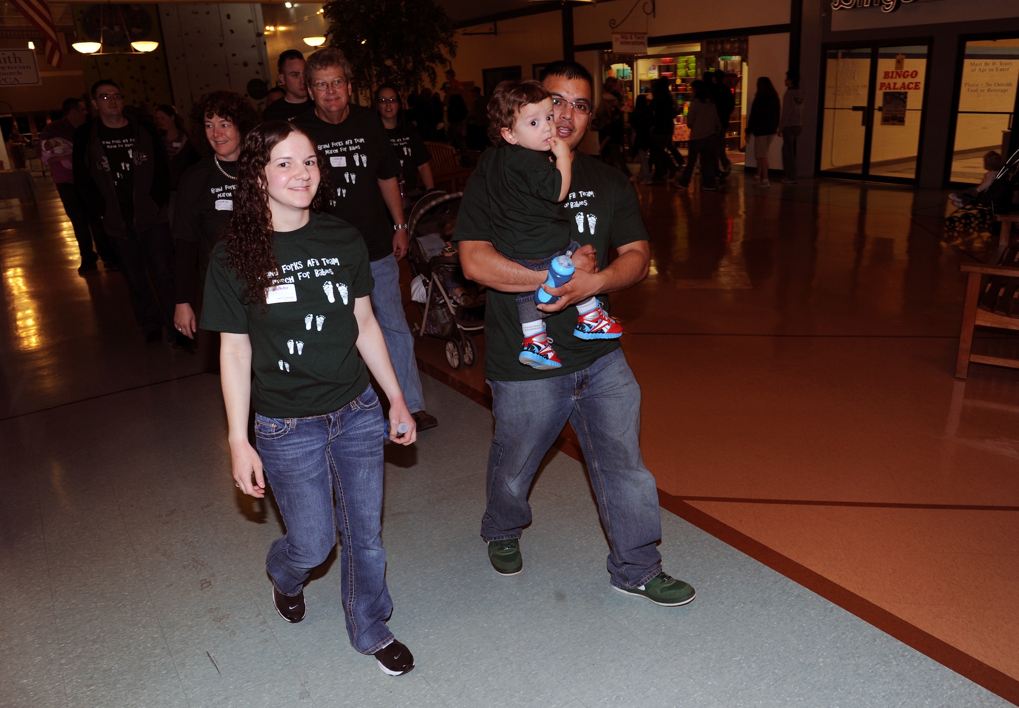 Staff Sgt. Tabatha Lugo, left, her husband, Staff Sgt. Alfredo Lugo, and their son, Matthias, lead the “March for Babies” fundraising walk at the Grand Cities Mall in downtown Grand Forks, N.D., on April 28, 2012. (U.S. Air Force photo/Tim Flack)
