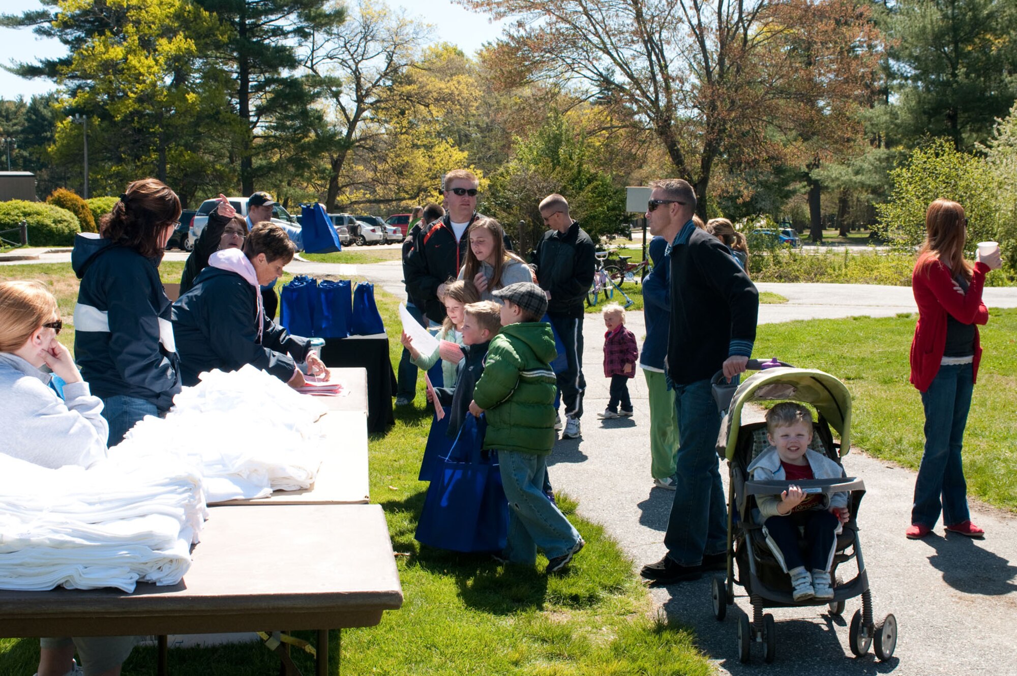 HANSCOM AIR FORCE BASE, Mass. – Families stop to pick up items at one of the informational booths set up at the Walk ‘n’ Talk event at Castle Park on April 28. Attendees were invited to gather information and materials from base and community organizations and talk about issues important to families as part of this culminating Month of the Military Child event. (U.S. Air Force photo by Mark Herlihy)