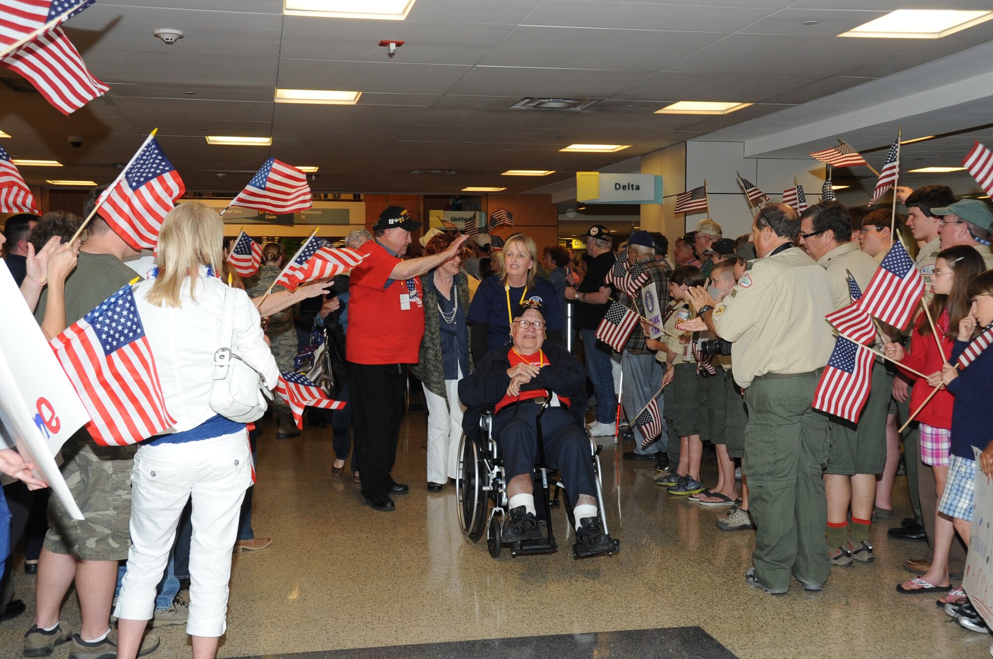Joann Griggs, 81st Diagnostic and Therapeutics Squadron, escorts World War II Army Air Corps veterans Albert Mangin and Bill Clark through a welcoming line after the veterans return from the third Mississippi Gulf Coast Honor Flight to Washington, D.C.,  April 24, 2012, at the Gulfport/Biloxi International Airport.  The Honor Flight program receives donations to honor our nation’s World War II veterans by sending them on a one-day visit to Arlington National Cemetery in Washington, D.C.   (U.S. Air Force photo by Kemberly Groue)