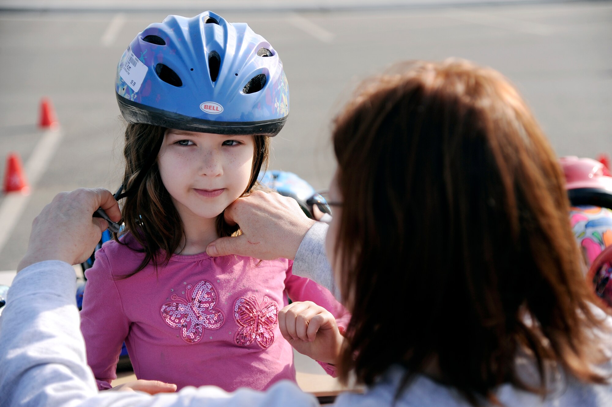 U.S. Air Force Master Sgt. Rebecca Theakston, 354th Fighter Wing Safety ground safety manager, helps Stacy Stamm, 6-year-old daughter of Staff Sgt. Aaron Stamm, 354th Maintenance Squadron assistant avionics flight chief, try on helmets during the 2nd Annual Children’s Safety Day April 30, 2012, Eielson Air Force Base, Alaska. During the event, children were educated on wearing proper safety gear when riding bicycles. (U.S. Air Force photo/Staff Sgt. Jim Araos)