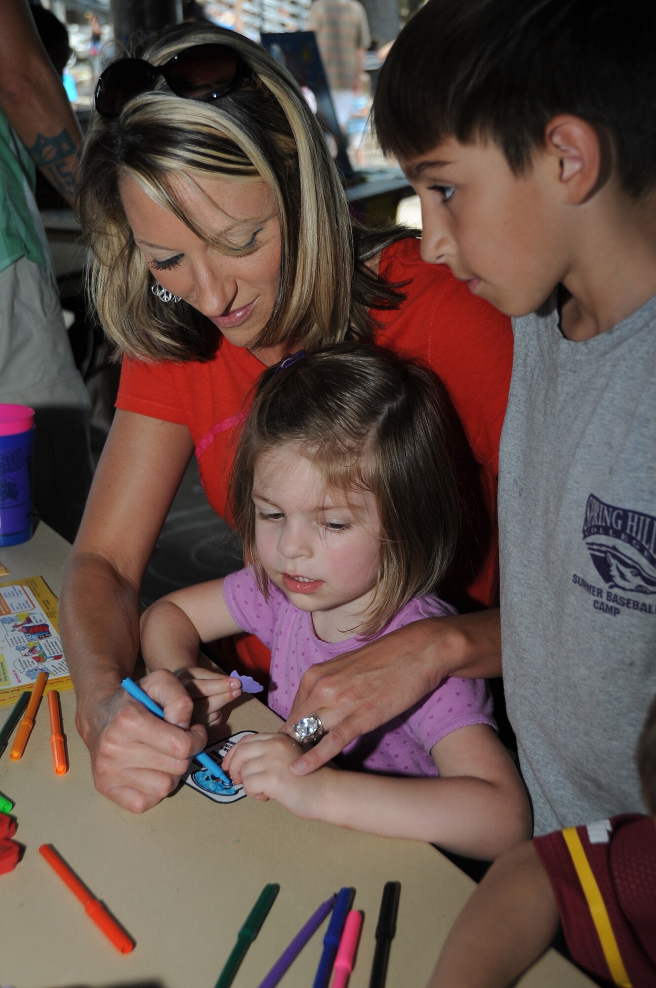 Michelle Belford and her children, Alyssa, 3, and ?, paint a magnet during Child Pride Day April 28, 2012, at Marina Park, Keesler Air Force Base, Miss.  Child Pride Day is an annual event held in conjunction with the month of the military child.  Booths, jumpers, activities, entertainment and food were set up throughout the park.  (U.S. Air Force photo by Kemberly Groue)