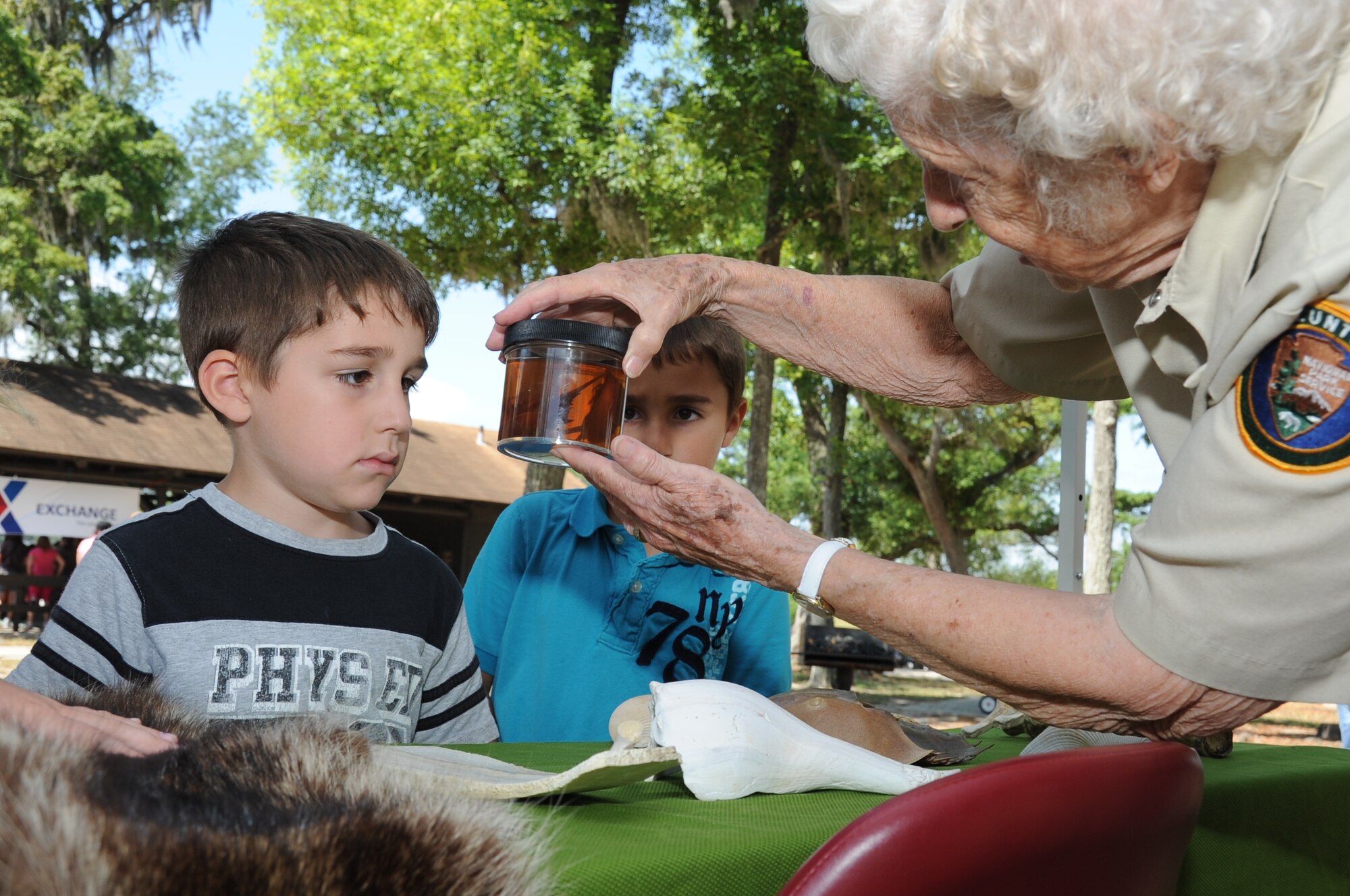 Justin, 5, and Jay Mares, 6, sons of Christina and Petty Officer 2nd Class Jeremy Mares, Branch Health Clinic, Naval Construction Battalion Center, Gulfport, Miss., inspect baby horseshoe crabs displayed by Sue Stanford, a volunteer for the National Park Service in Ocean Springs, Miss., during Child Pride Day April 28, 2012, at Marina Park, Keesler Air Force Base, Miss.  Child Pride Day is an annual event held in conjunction with the month of the military child.  Booths, jumpers, activities, entertainment and food were set up throughout the park.  (U.S. Air Force photo by Kemberly Groue)