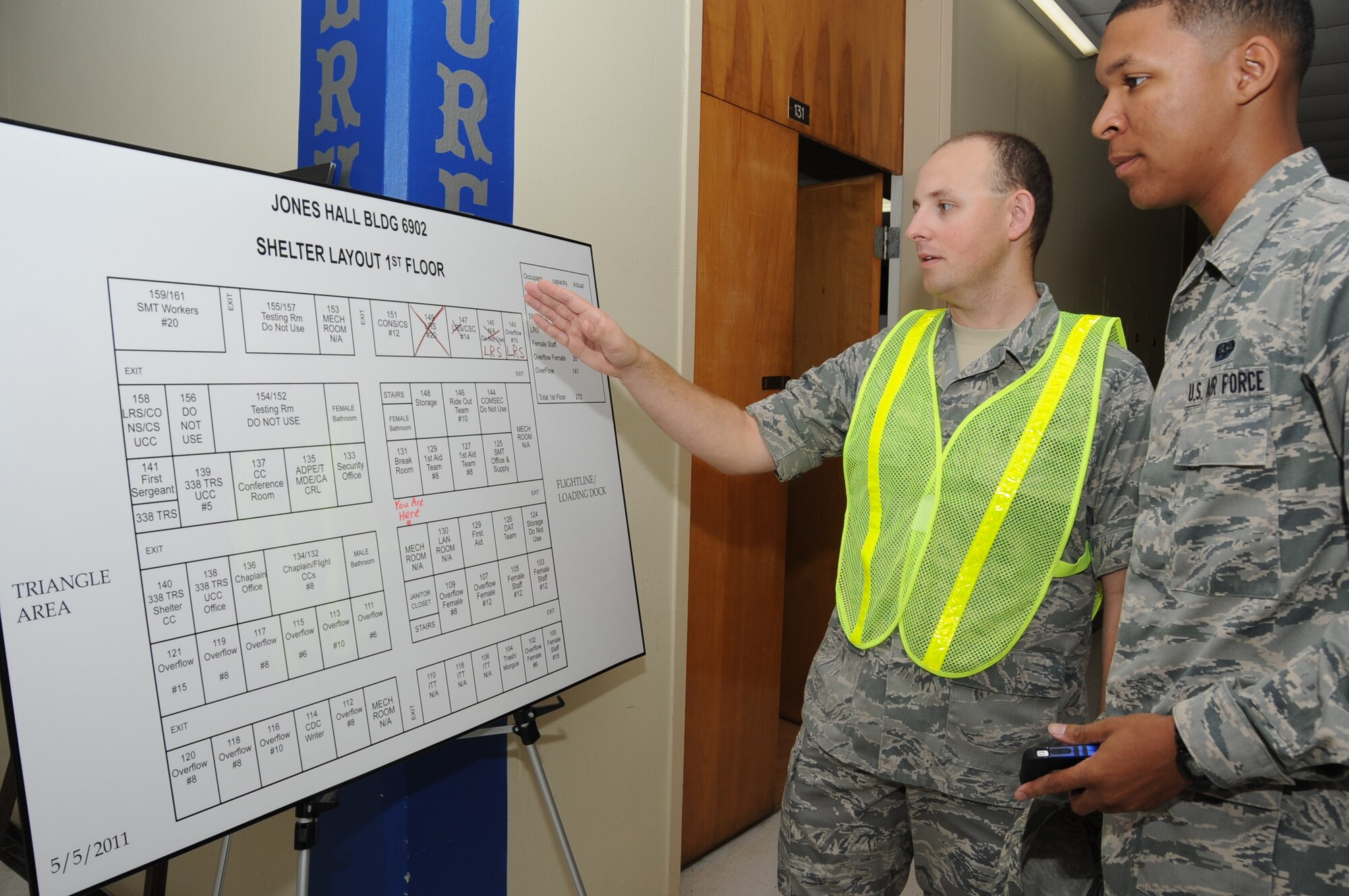 Staff Sgt. Jonathan Okeefe, 338th Training Squadron, shows a diagram of assigned rooms for sheltering at Jones Hall to Airman 1st Class Jerreald Hickman, 81st Communications Squadron, as he inprocesses into the shelter during a Hurricane Condition Exercise April 27, 2012, at Keesler Air Force Base, Miss. The exercise was held from April 23-27 in preparation for hurricane season which runs from June 1 thru Nov. 30.  (U.S. Air Force photo by Kemberly Groue)