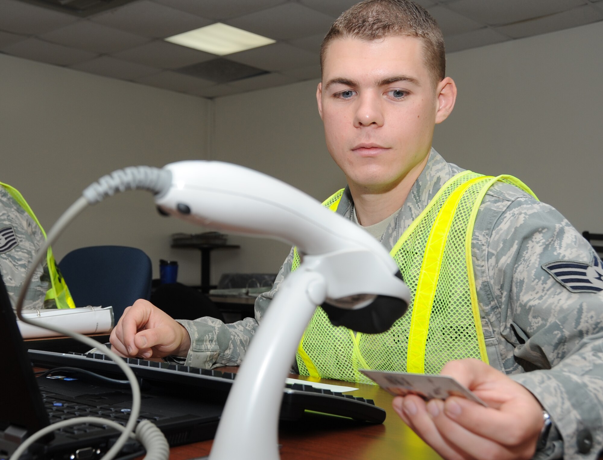 Staff Sgt. Brandon Fidler, 338th Training Squadron, scans a Comman Access Card at Jones Hall as individuals inprocess  to shelter during a Hurricane Condition Exercise April 27, 2012, at Keesler Air Force Base, Miss. The exercise was held from April 23-27 in preparation for hurricane season which runs from June 1 thru Nov. 30.  (U.S. Air Force photo by Kemberly Groue)