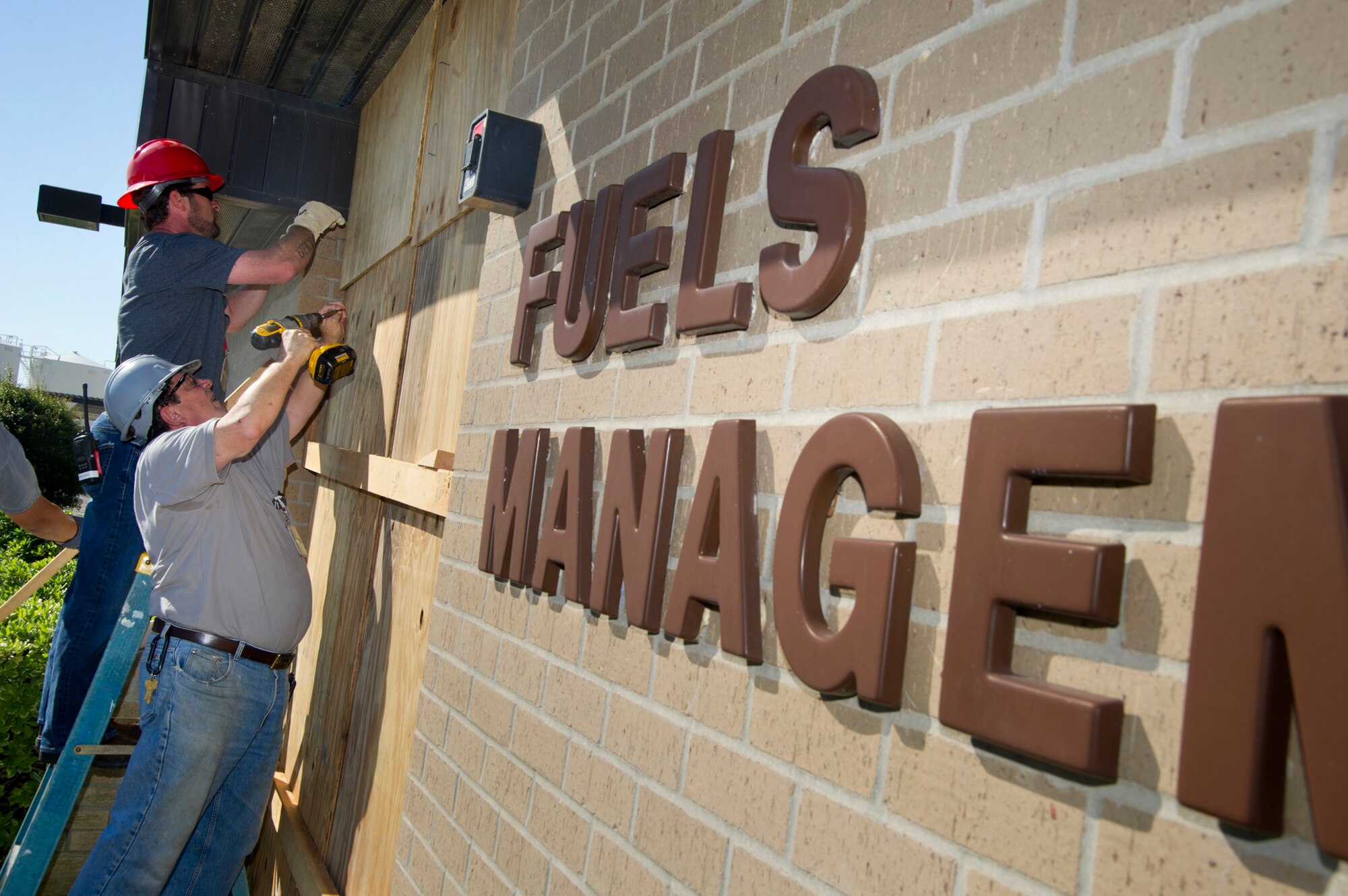 Dennis Johnson and Jason Bullock of CSC complete the hardening of the Fuels Management building by securing the boards protecting the front doors during a hurricane condition Exercise April 25, 2012, at Keesler Air Force Base, Miss. The hardening exercise is in preparation for the 2012 hurricane season which runs from June 1 to Nov. 30.  (U.S. Air Force photo by Adam Bond)