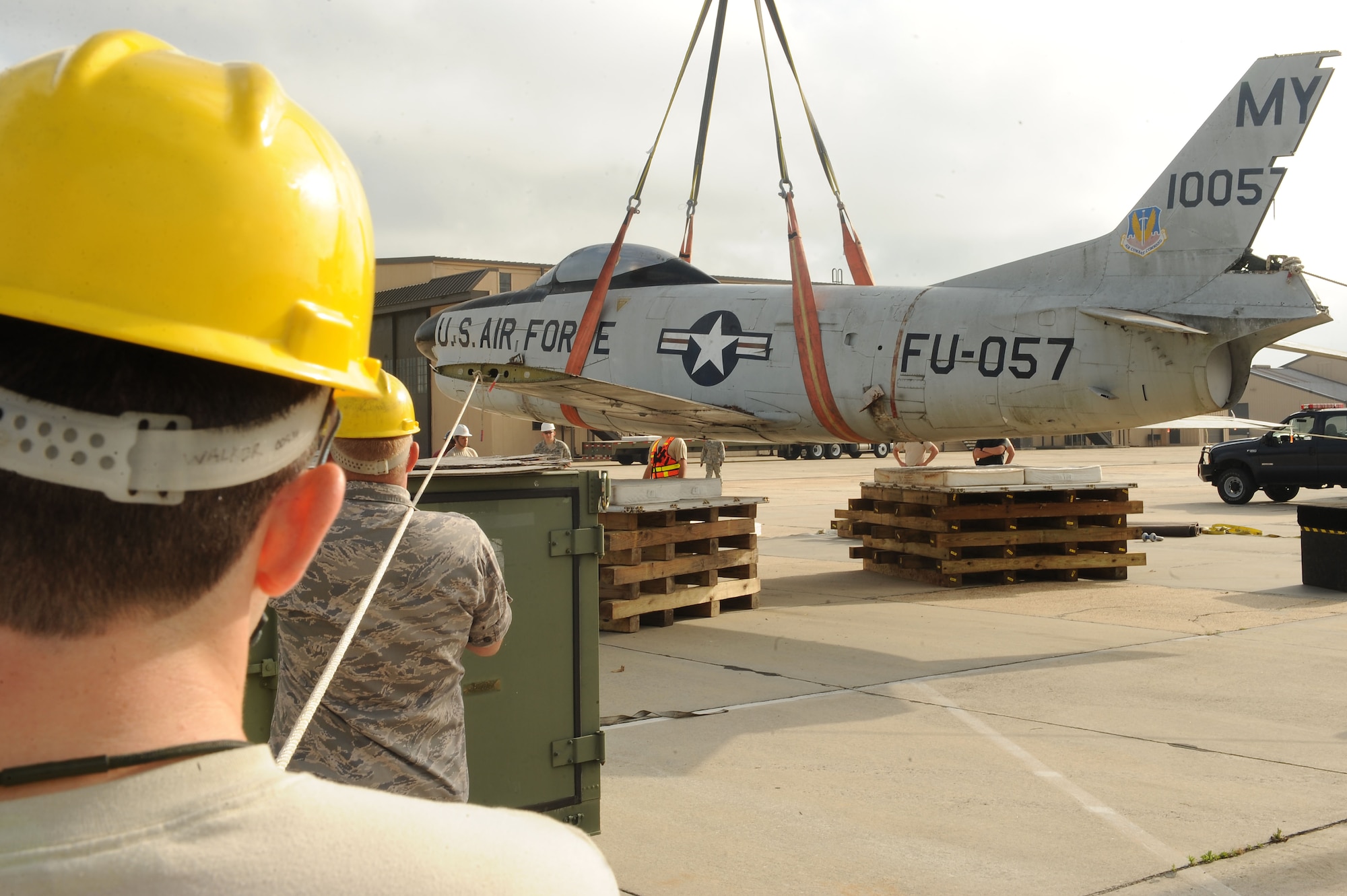 Airmen from the 23d Equipment Maintenance Squadron, use ropes to guide an F-86L Sabre at Moody Air Force Base, Ga., May 1, 2012. Airmen from 23d EMS were on site to help keep the plane steady while being transferred from a flatbed truck to a pallet for restoration. (U.S. Air Force photo by Staff Sgt. Ciara Wymbs/Released) 