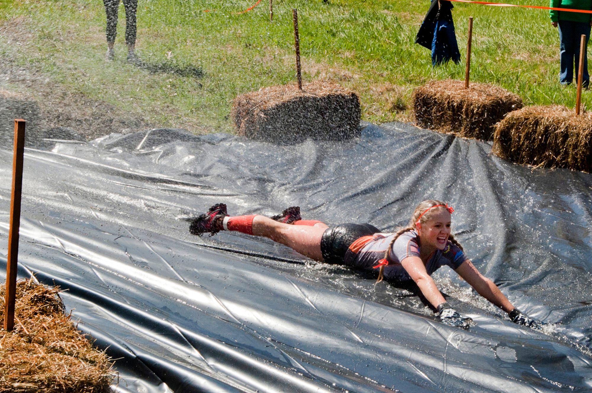 MANCHESTER, N.H. -- Tech. Sgt. Jessie Davidson slides down the final obstacle during the Adventure 5k at McIntyre Ski area April 28. Davidson and ten others from the New Hampshire Air National Guard participated as a team called Obstacle Illusion. More than 800 participants ran through mud trails and over obstacles during the 3.1 mile event. (National Guard photo by Tech. Sgt. Mark Wyatt/Released)