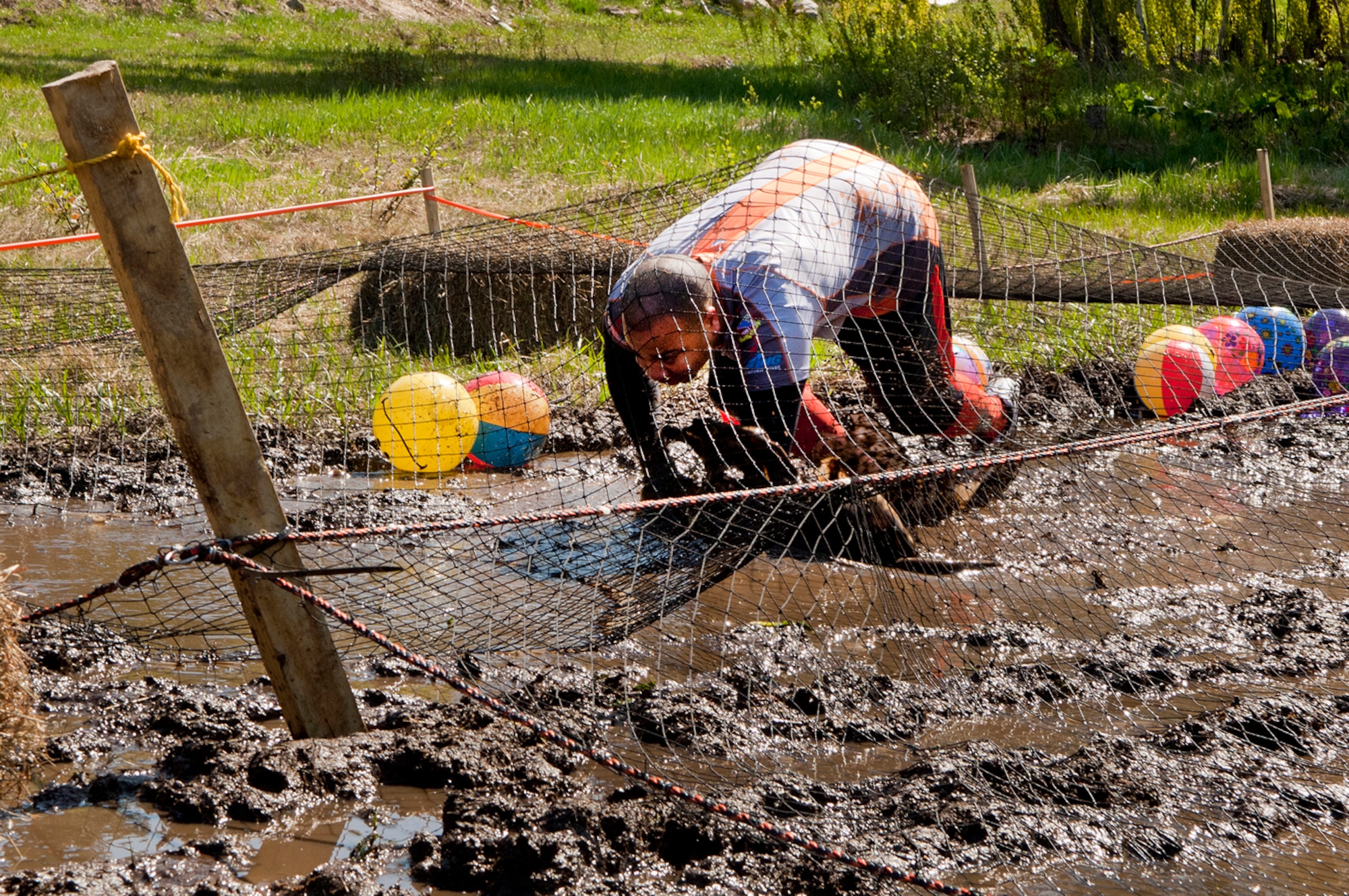 MANCHESTER, N.H. -- Staff Sgt. Alex Smith navigates through a mud obstacle at the Adventure 5k at McIntyre Ski area April 28. Smith and ten others from the New Hampshire Air National Guard participated as a team called Obstacle Illusion. (National Guard photo by Tech. Sgt. Mark Wyatt/Released)