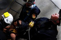 Firefighters with Schriever and Colorado Springs Fire Departments secure a “victim” for lift during confined-space training May 1 at Schriever Air Force Base. During the training, the firefighters learned how to integrate equipment and personnel as well as plan for tactics and strategies to remove a victim from confined spaces. (U.S. Air Force photo/Staff Sgt. Julius Delos Reyes)