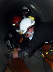 Firefighters with the Schriever and Colorado Springs Fire Departments secure a “victim” for transport during confined-space training May 1 at Schriever Air Force Base. Staying proficient at confined space entries, rescues and recoveries is a federal and Air Force requirement. (U.S. Air Force photo/Staff Sgt. Julius Delos Reyes)