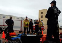 David Cates, Colorado Springs Fire Department firefighter 1st class, shows some of CSFD’s equipment to Schriever Fire Deparment personnel during confined-space training May 1 at Schriever. During the training, the firefighters learned how to integrate equipment and personnel as well as plan for tactics and strategies to remove a victim from confined spaces. 