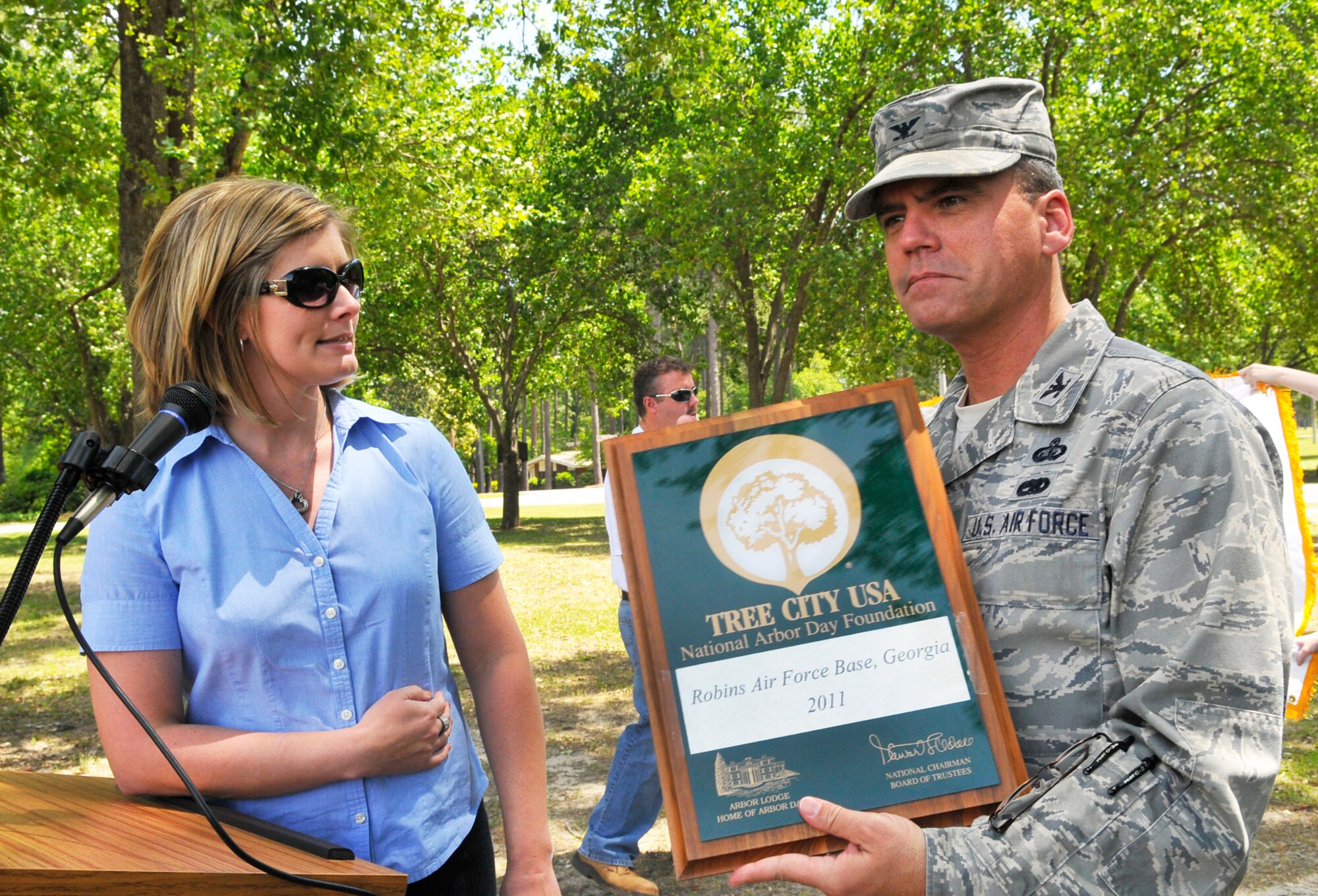 Wendy Burnett of the Georgia Forestry Commission presents  a plaque to Col. David Southerland, 78th Air Base Wing vice commander, recognizing Robins as a Tree City USA for the 19th consecutive year. (U. S. Air Force photo by Sue Sapp)