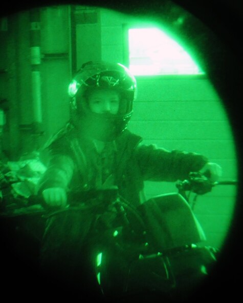 “It was cool to see all the things police use to work,” said 1st grader Jacob Trower, a photojournalist for the day. (Jacob checks out a 100th Security Forces Squadron all-terrain vehicle while his brother Scott takes his photo through a night vision monocular during Job Shadow Day here April 27, 2012. Learning to be a photojournalist, like his father who works at the 100th Air Refueling Wing Public Affairs office, 8-year-old Scott documented the day’s events with his camera.) (U.S. Air Force photo/Scott Trower)