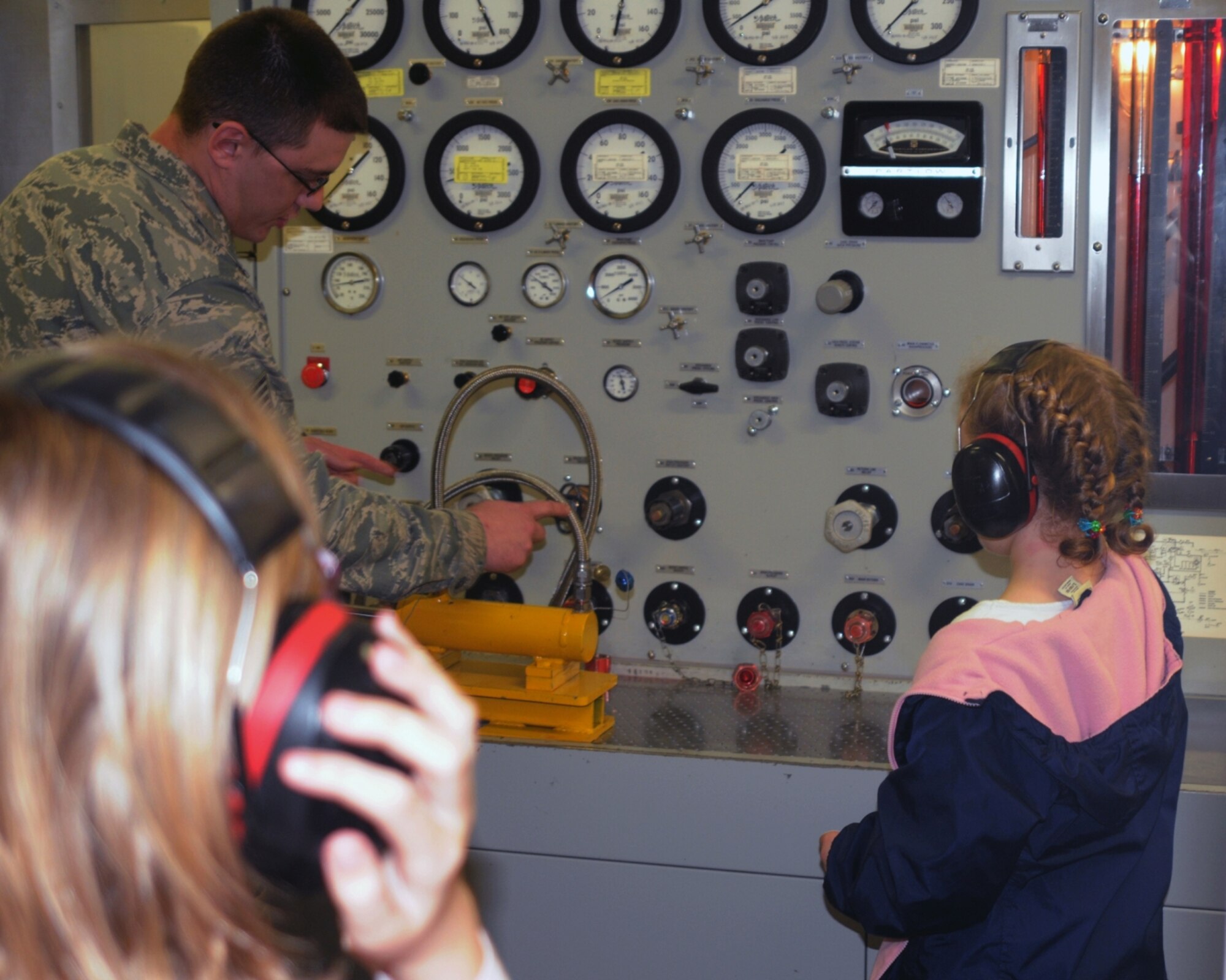 “When they were about to start the pressure, they said the noise would be loud so everyone around there, including me, covered our ears. The loud sound never came but they asked us if we wanted to pull the trigger to make the machine move and gave us ear muffs,” said 4th grader Liam Wallace, a photojournalist for the day. (A hydraulics mechanic from the 100th Maintenance Squadron demonstrates how high pressure hydraulic fluid can actuate a KC-135 Stratotanker hydraulic component using a hydro-test stand. The demonstration was put on for a group of base children during Job Shadow Day here April 27, 2012, and visiting children got to flip the lever to actuate the test stand. Learning to be a photojournalist, like his father who works at the 100th Air Refueling Wing Public Affairs office, 10-year-old Liam Wallace captures the demonstration on his camera.) (U.S. Air Force photo/Liam Wallace)