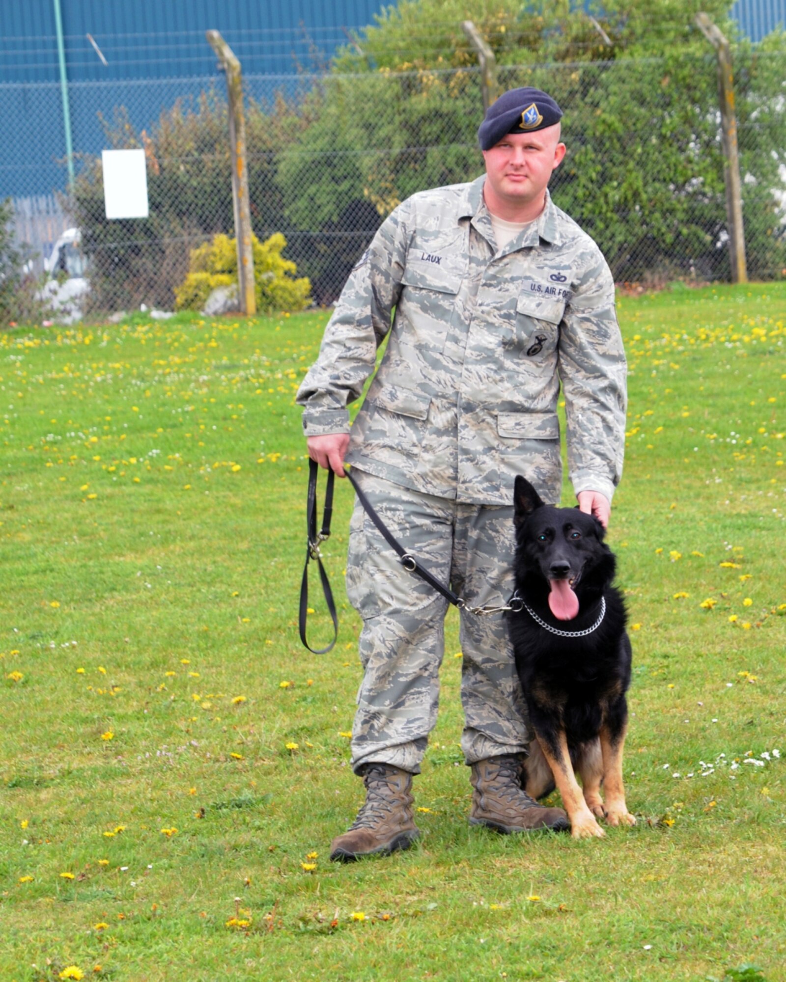 “When I got to the dog kennels the first thing I saw was this man standing side by side with his trained dog. I thought they looked proud and it looked like they were ready to do whatever they had to do,” said 10-year-old Liam Wallace, a photojournalist for the day. (Staff Sgt. Jason Laux, 100th Security Forces military working dog handler, prepares his MWD for a demonstration for a group of base children during Job Shadow Day at the base kennels here April 27, 2012. Learning to be a photojournalist, like his father who works at the 100th Air Refueling Wing Public Affairs office, 4th grader Liam Wallace captures Laux prior to the demonstration start.) (U.S. Air Force photo/Liam Wallace)
