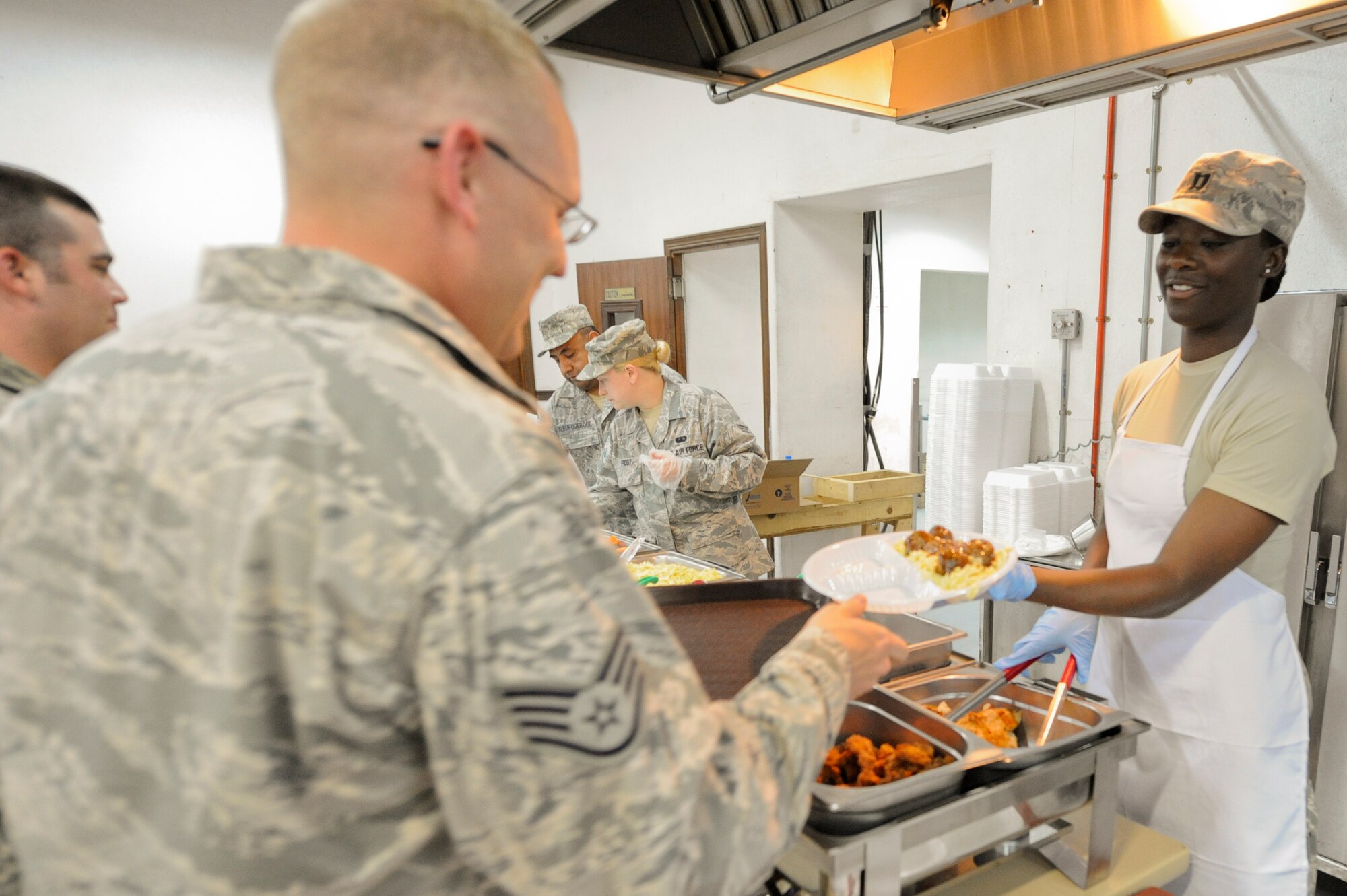 SOUTHWEST ASIA -- Captain Vanessa Jessie, 332nd Expeditionary Force Support Squadron, serves lunch to a 332nd Air Expeditionary Wing Airman here, May 1, 2012. The 332nd EFSS serves four hot meals a day to ensure all shift workers can eat nutritious meals. Jessie is deployed from Moody Air Force Base, Ga.(U.S. Air Force photo by Staff Sgt. Joshua J. Garcia)