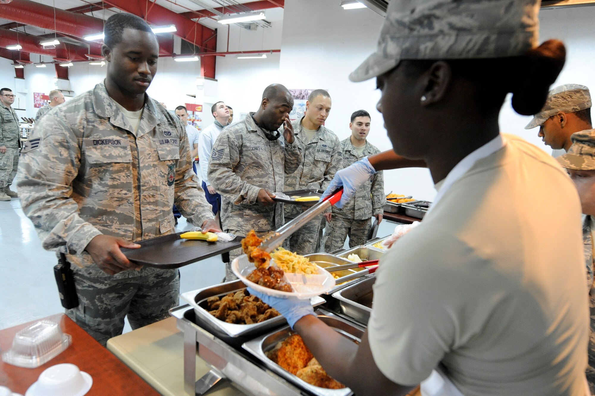 SOUTHWEST ASIA -- Captain Vanessa Jessie, 332nd Expeditionary Force Support Squadron member  serves Senior Airman Courtland Dickerson, 332nd Expeditionary Civil Engineer Squadron fire fighter, during the lunch meal here, May 1, 2012. Squadron leadership for the 332nd EFSS helped with the preparation and serving of the meal. Dickerson is deployed from Joint Base Pearl Harbor-Hickam, Hi, and is a native of Georgia. Jessie is deployed from Moody Air Force Base, Ga. (U.S. Air Force photo by Staff Sgt. Joshua J. Garcia)