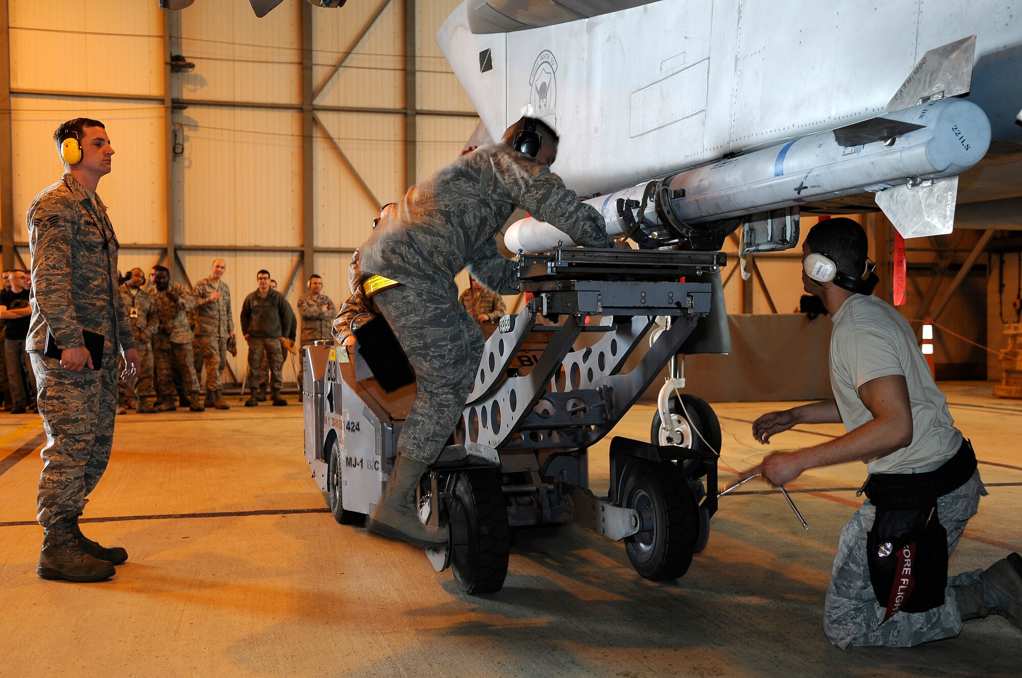 ROYAL AIR FORCE LAKENHEATH, England -- Weapons load crew team members from the 493rd Aircraft Maintenance Unit prepare to load an Air Intercept Missle-120 munition onto an F-15C Eagle during the quarterly Load Crew Competition April 20, 2012. The competition features the best load crew teams from the 492nd, 493rd and 494th AMUs. The winner is determined by the fastest time loading munitions with the least amount of errors.  (U.S. Air Force photo by Staff Sgt. Connor Estes)