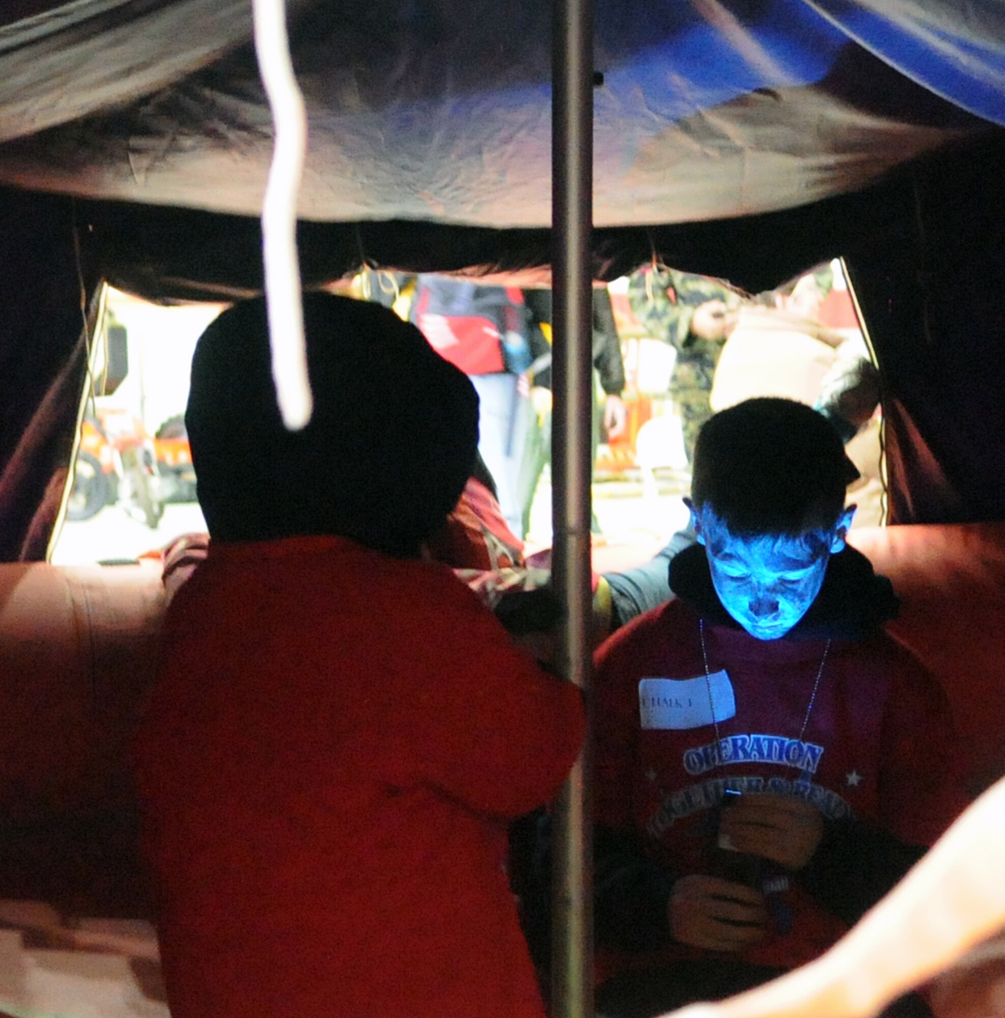 RAF MILDENHALL, England -- Elijah, son of 100th Operations Support Squadron Commander Lt. Col. Chris Bennett, examines a strobe light in a survival raft at Operation Together and Ready here April 28, 2012. Survival, Evasion, Resistance and Escape equipment was one of several displays available to the families of Airmen who attended the event geared towards educating children on the deployment process. (U.S. Air Force photo/Staff Sgt. Thomas Trower)
